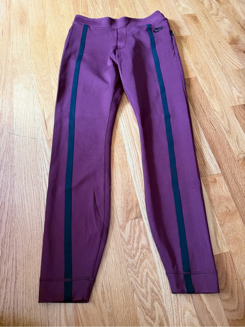 Burgundy/purple Nike leggings featuring a dark side stripe. Women's Small